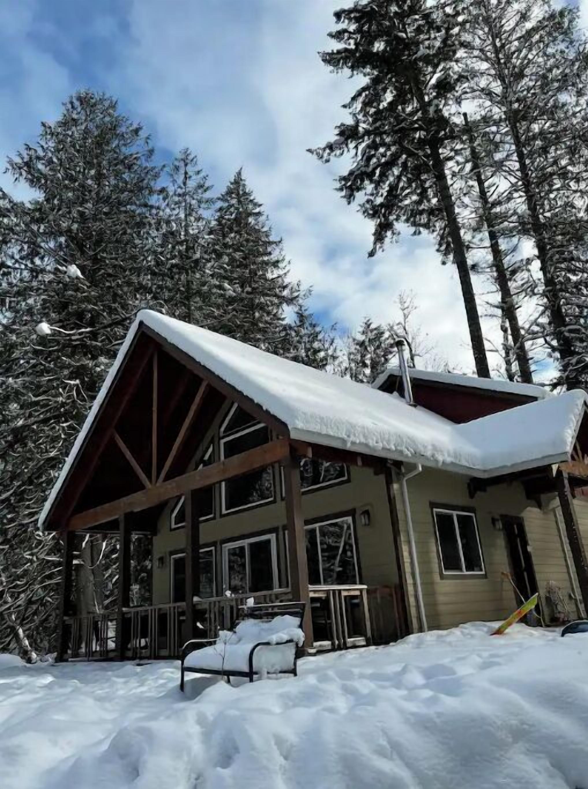 Una baita con tetto spiovente, travi di legno e un portico.