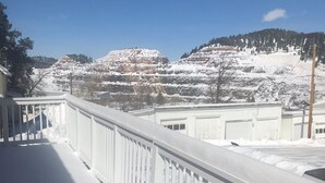 A snow-covered balcony with a view of a mountainous landscape.