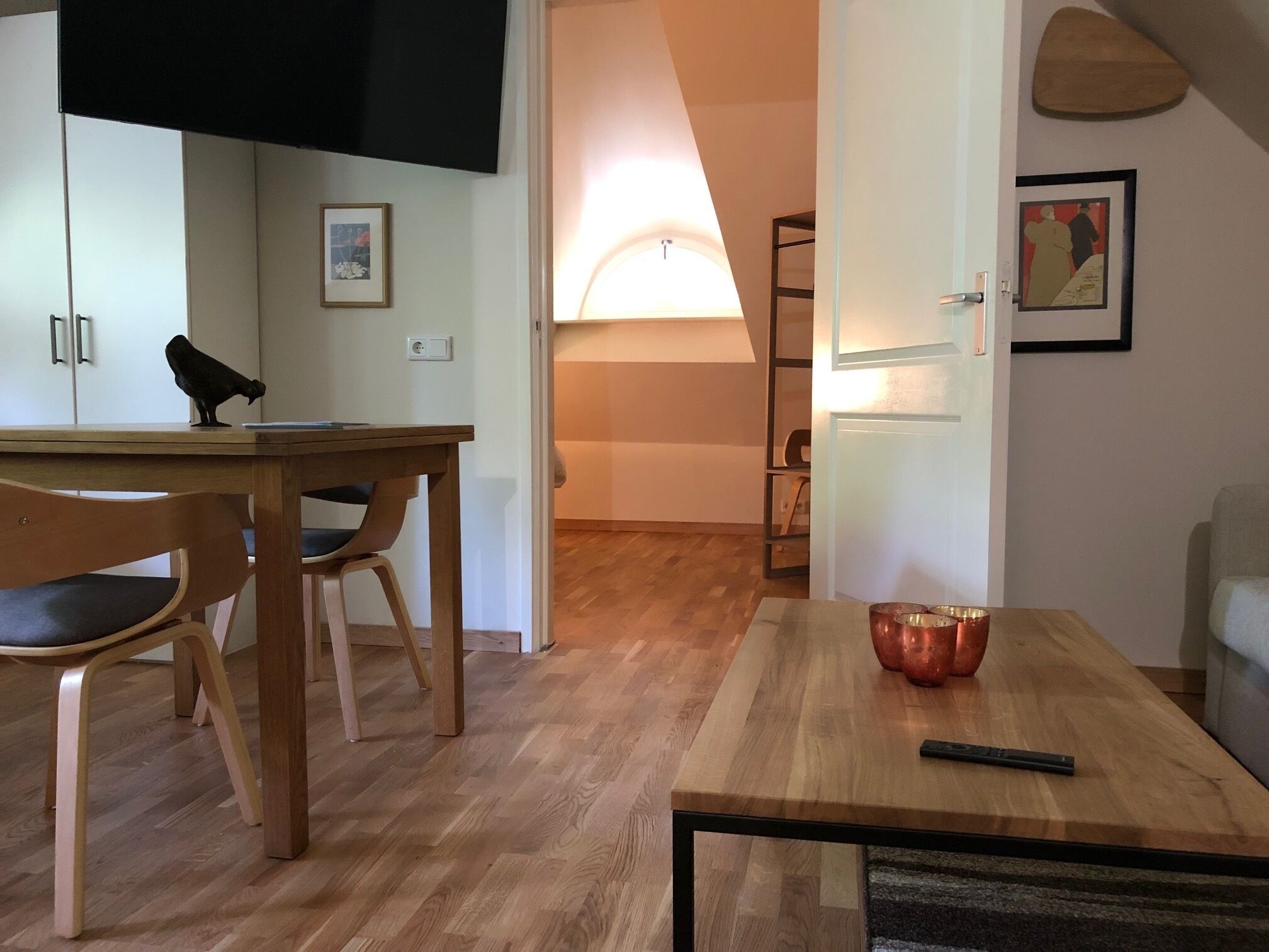 Un comedor con una mesa de madera, sillas y un objeto negro sobre la mesa.