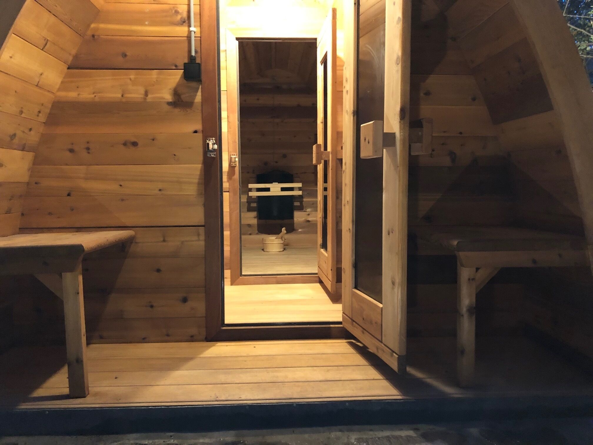 A wooden staircase leading to a loft bedroom with a bed and a small table.