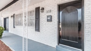 A white brick building with black doors and windows, numbered 333, and a black mailbox.