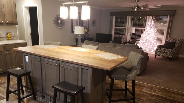 A modern kitchen with a central island, bar stools, and a dining area with a sofa and chairs. - Mi Casa is your home Beautiful views (Biltmore lakes)