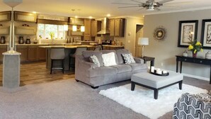 A modern living room with a grey sofa, a white rug, and a ceiling fan. - Mi Casa is your home Beautiful views (Biltmore lakes)