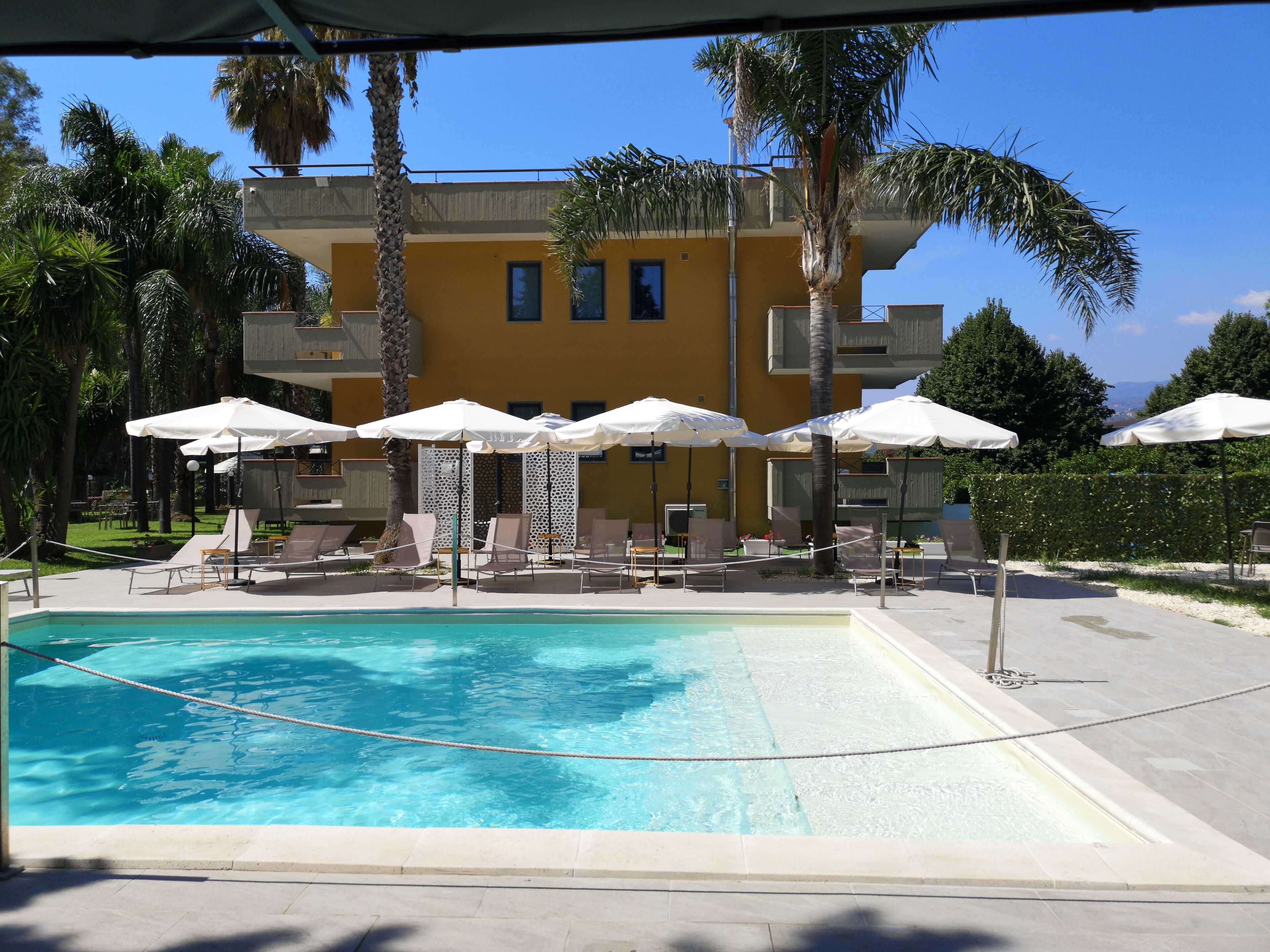 Una piscina al aire libre de temporada, sombrillas
