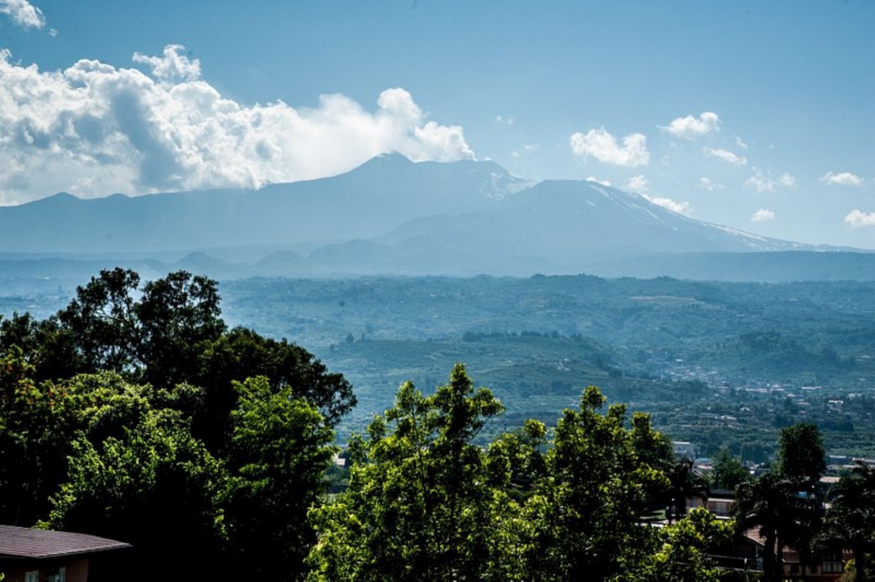 A mountain with a clear sky and clouds.