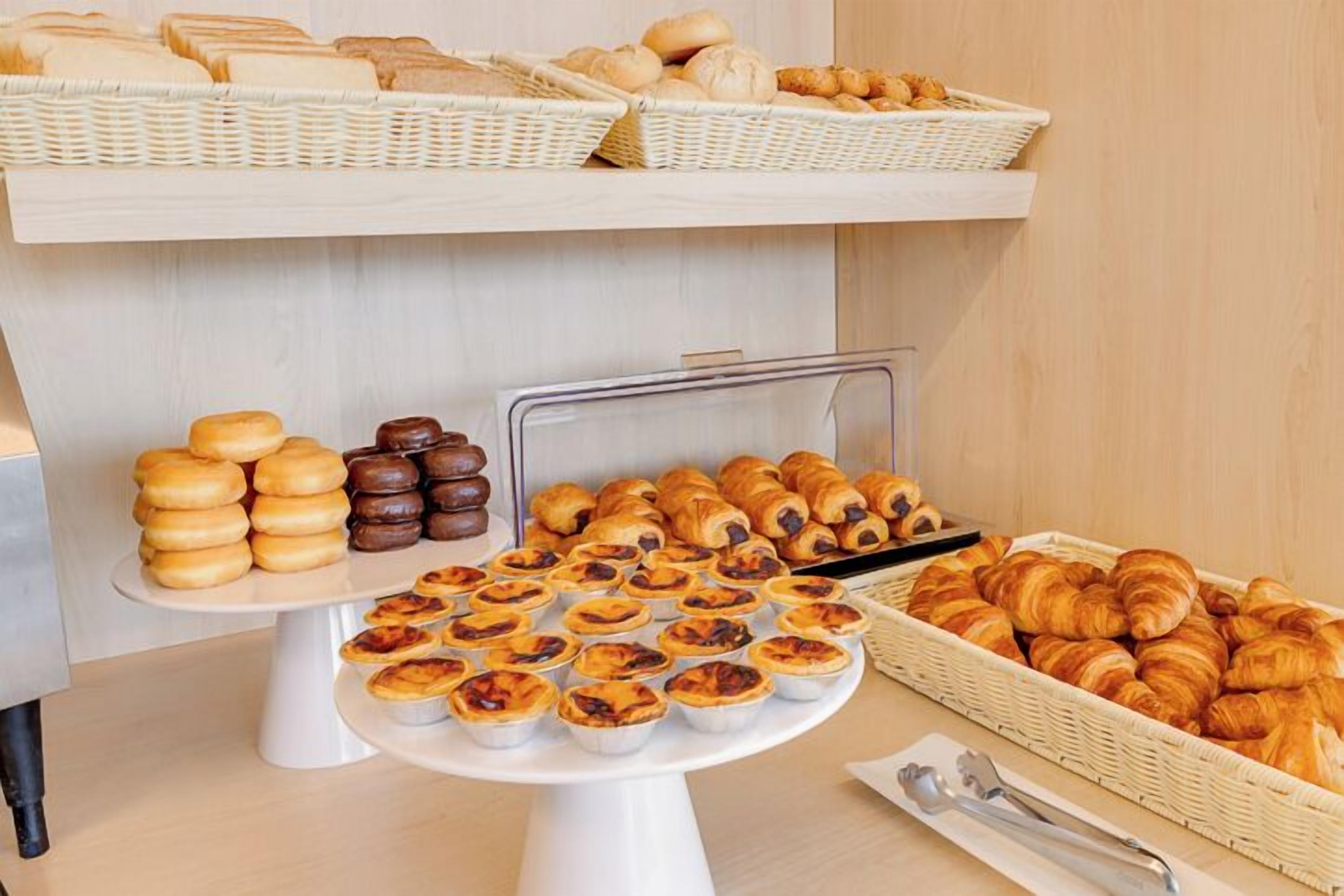 Ein Buffet mit verschiedenen Backwaren, darunter Gebäck, Brot und Torten.
