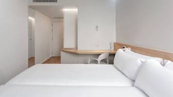 Una habitación de hotel moderna con cama, escritorio y silla.