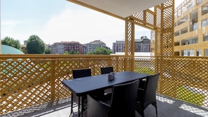 A balcony with a yellow lattice partition, a table, and two chairs. - Italianway Comfort - Flavio Gioia 5 B - Bilo (Milan)