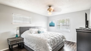 A bedroom with a bed, nightstand, dresser, ceiling fan, and artwork on the walls. -  POOL, Sleeps 10, CENTRALY LOCATED, game room, pets. great for LONG TERM stays. (El Paso)