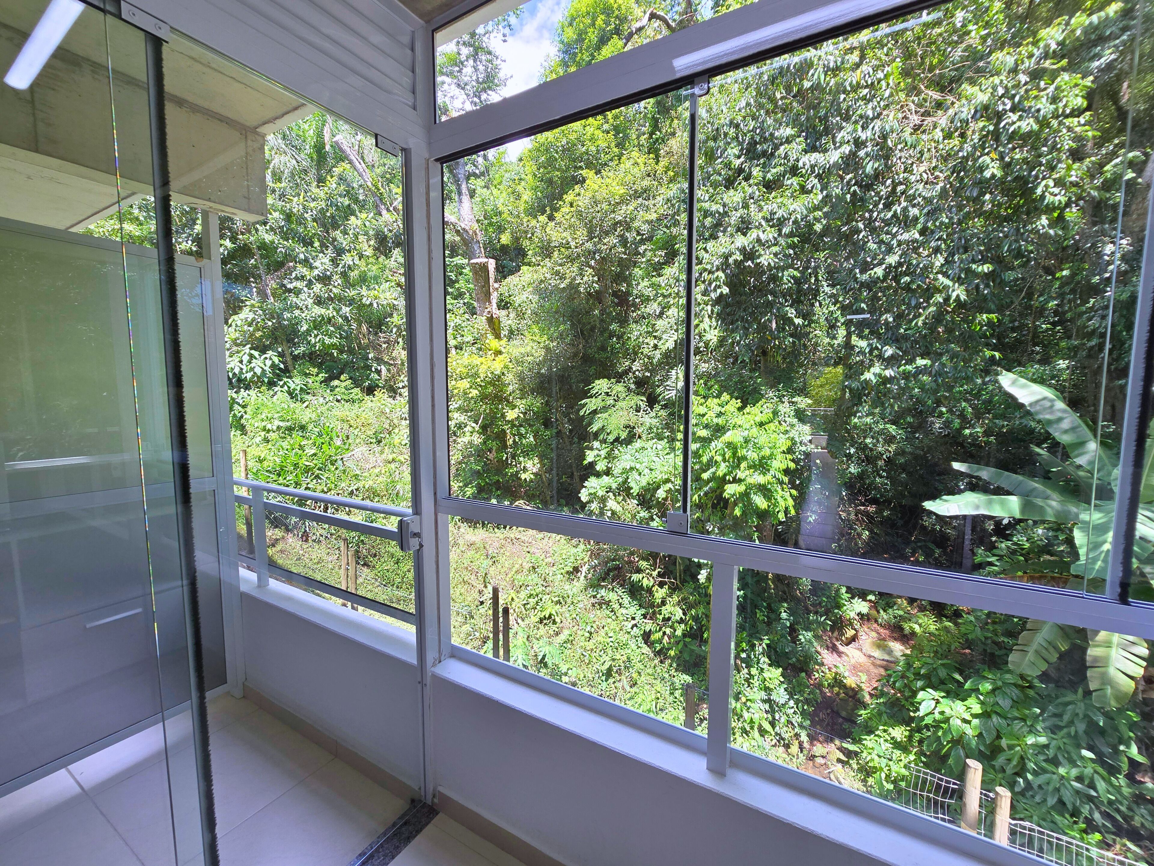 A room with a large window overlooking a lush garden.