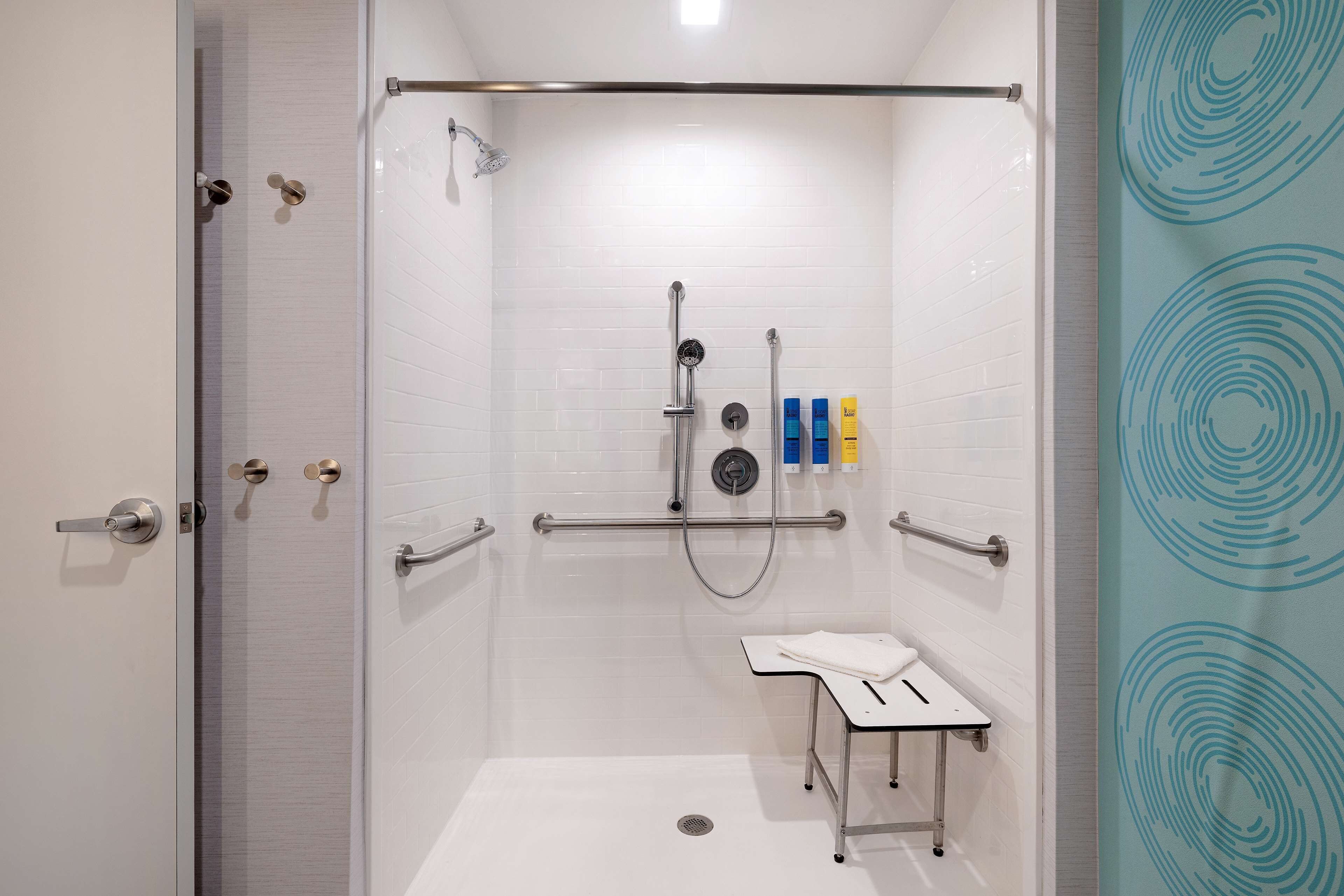 Una ducha a nivel con puerta de cristal y múltiples cabezales de ducha de mano.
