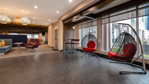 Un hall espacioso con asientos modernos, ventanas amplias y luminarias contemporáneas.