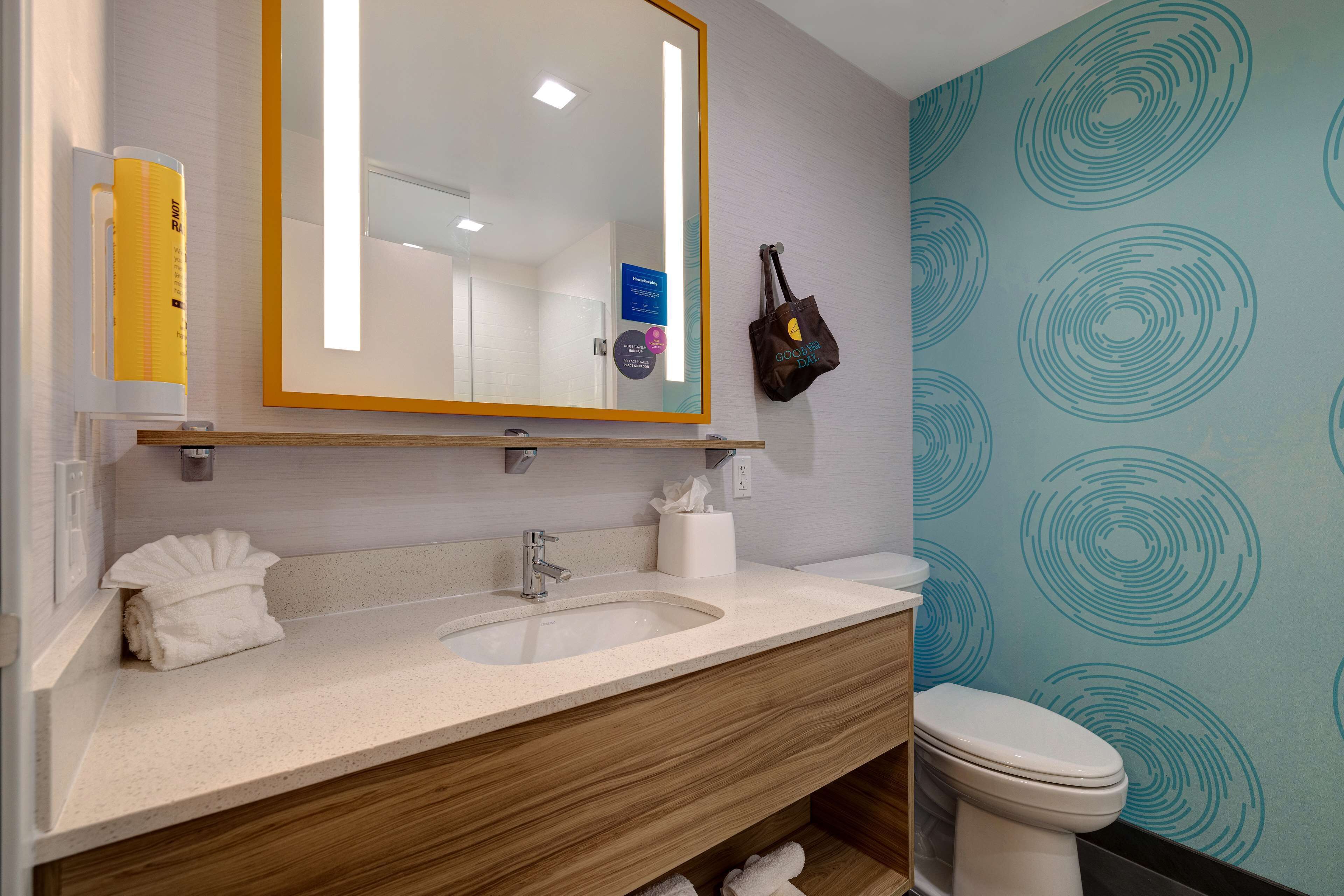 A bathroom with a sink, mirror, towel rack, and toilet.