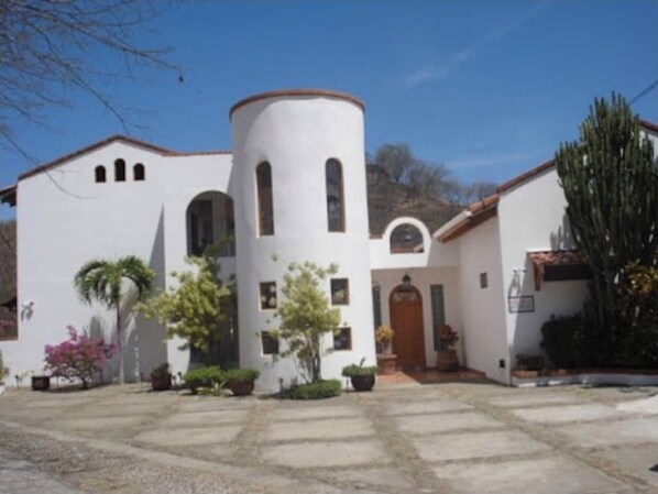A white building with a central tower, arched windows, and a door.