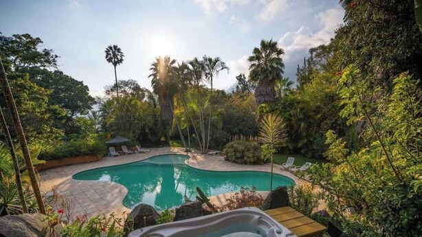 A private pool surrounded by lush greenery and palm trees. - Beautiful Lakefront home: gardens  (Santiago Atitlan)