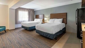 A hotel room with two beds, a desk, a refrigerator, and a window with curtains. - MainStay Suites Lexington I-75 (Lexington)