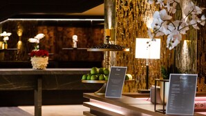 Ein Empfangsbereich mit modernem Design, der eine Rezeption mit beleuchteten Paneelen und einer dekorativen Orchideenanordnung zeigt.