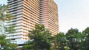 Ein Hochhaus-Hotel mit Schwimmbad davor.