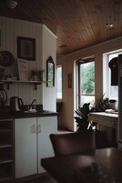 Una cocina con armarios de madera, un lavamanos y un ventanal.