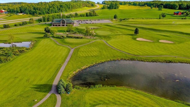 A golf course with a clubhouse, ponds, and a large open field. - Cabin #9 -" Flag-up " (Cadillac)