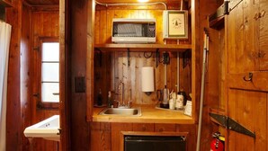 A compact kitchen with a microwave, sink, and a small refrigerator. - Cabin #9 -" Flag-up " (Cadillac)