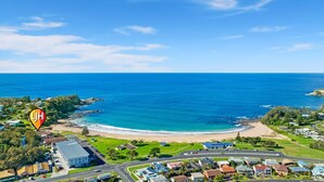A coastal town with a beach, residential areas, and a prominent building with a blue roof. - Malua Dream on Kuppa Avenue (MALUA BAY)