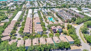 An aerial view of a residential area with houses, a swimming pool, and a road. - KonoVilla * Dog Friendly * Best Lagoon Pool in Destin (Destin)