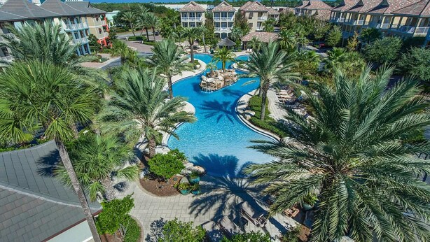 A resort with a central swimming pool, palm trees, and multiple hotel buildings. - KonoVilla * Dog Friendly * Best Lagoon Pool in Destin (Destin)