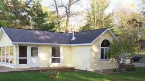 A single-story house with a gabled roof, a front porch, and a chimney. - Maggies on the Bayou, close to Hiking, Beaches, Boating, Golf (Ludington)