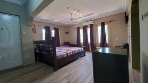 A bedroom with a bed, a desk, and a ceiling fan.