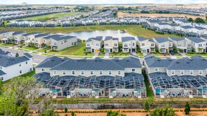 A residential area with modern houses, a central pond, and a well-maintained lawn. - Sunnyside Cliffs | Near Attractions | Private Pool (Davenport)