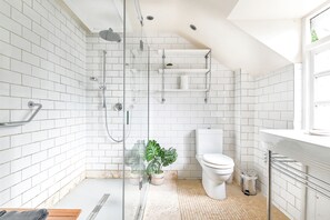 Een douche, handdoeken, zeep, toiletpapier