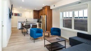 Een modern appartement met keuken, eethoek en zithoek.