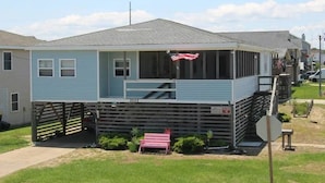 A single-story house with a porch, a small deck, and a red bench. - "The Hammock Cottage" (Kill Devil Hills)