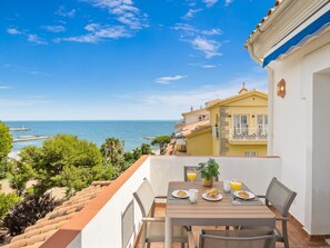 A balcony with a table set for breakfast overlooking a coastal view. - Penthouse in Andalucia del Mar for 2 people | ADM 4-504 (Puerto Banús - Marbella)