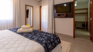 Ein Hotelzimmer mit einem großen Bett, einem Wand-Fernseher und einem Holzschrank.