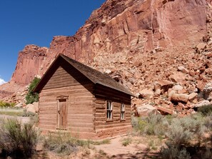 Experience a rustic cabin amidst a natural landscape with a simple, functional design and a unique historical charm.