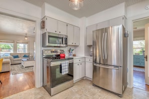 Enjoy cooking in this well-equipped kitchen with stainless steel appliances, including a double-door refrigerator and microwave oven.
