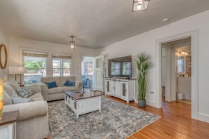 Relax in this stylish living room with a sofa, armchair, and flat-screen TV.