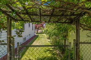 Stroll through the serene garden, surrounded by a beautifully maintained lawn and a charming pergola.