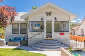 A house with a front porch, stone steps, a butterfly decoration, and a small pool. - Butterfly: Downtown Stay Near CMU (Grand Junction)