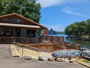 A wooden building labeled "WAYPOINT" with a deck overlooking a lake. - Back of the 9 - Charming townhome w/ lake views (Hot Springs)