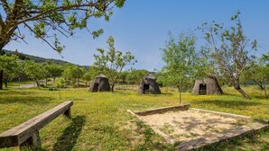 A rural landscape with thatched-roof huts and a wooden bench. - Montion Jimera de Libar by Ruralidays (Málaga)