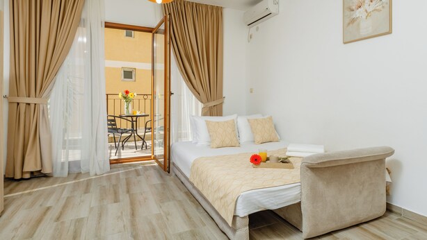 Habitación de hotel con cama, una silla, una mesa y vistas al exterior.