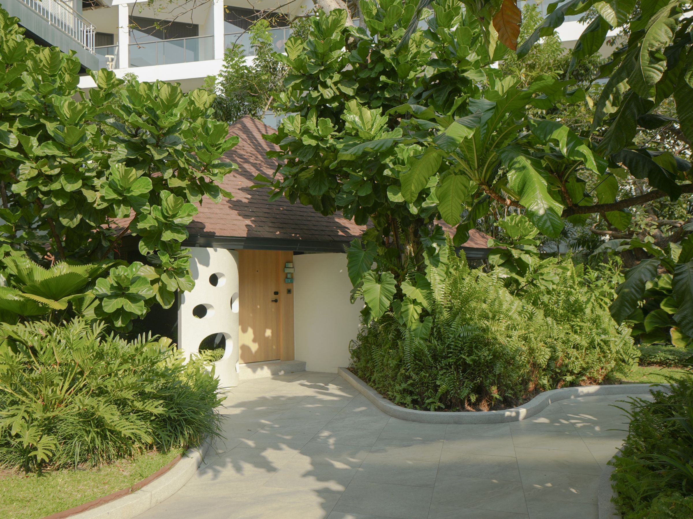 Un edificio con un diseño arquitectónico único, que presenta un ventanal circular en la fachada y una pequeña entrada.
