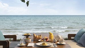 Una mesa preparada para el desayuno con vista al océano.