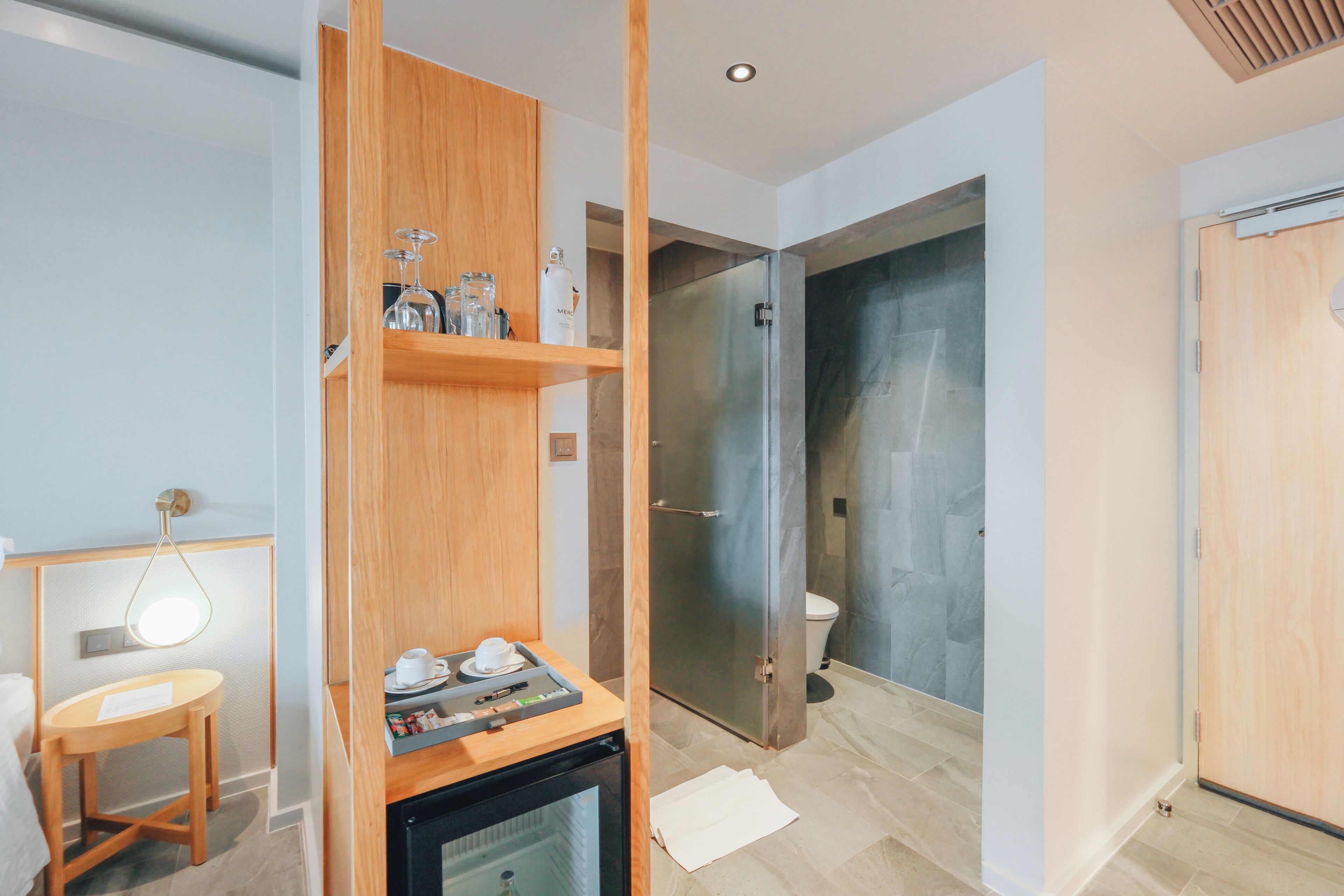 Un baño moderno con ducha, inodoro y tocador de madera con lavamanos y encimera.