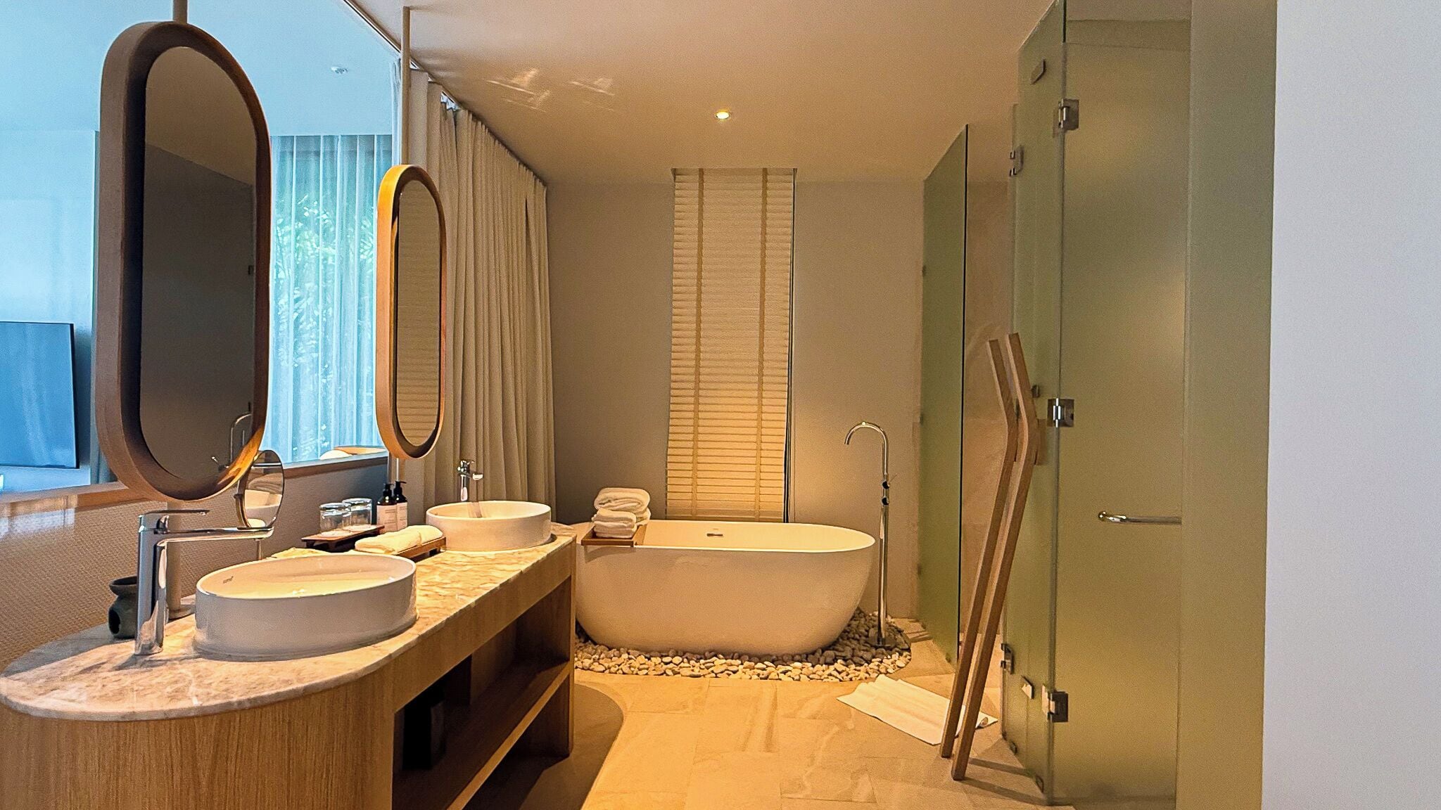 Ein modernes Badezimmer mit zwei Waschbecken, einer großen Badewanne und einem Spiegel.