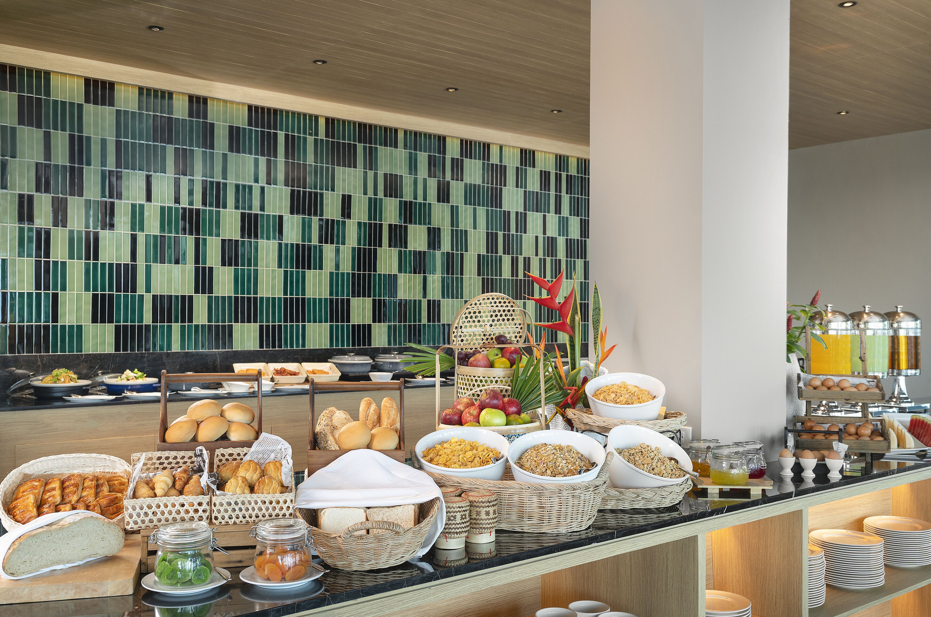 A buffet with various food items and a decorative wall in the background.