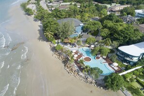 An aerial view of a coastal resort with a swimming pool, beachfront, and lush greenery. - Mercure Rayong Lomtalay Villas & Resort (Klaeng)